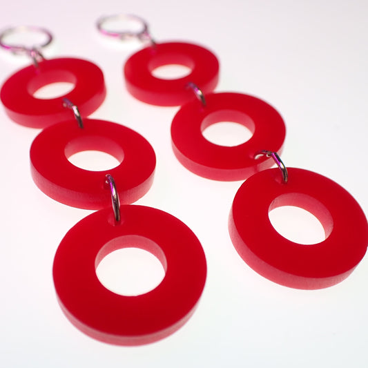 Red phish donut earrings on a white background